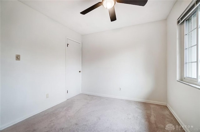 spare room with ceiling fan and light colored carpet