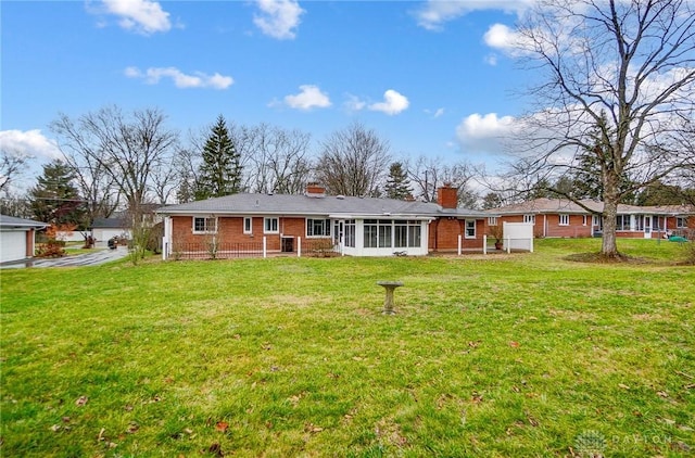 rear view of property with a sunroom and a lawn