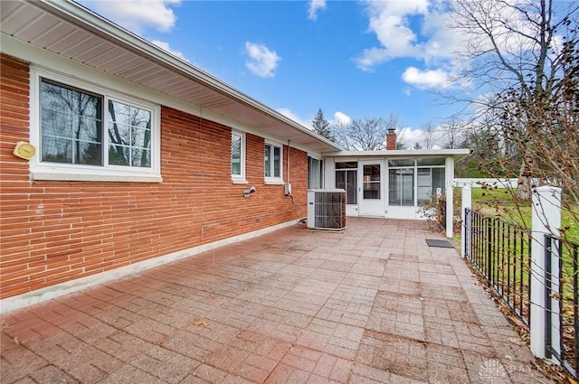 view of patio / terrace featuring central air condition unit and a sunroom