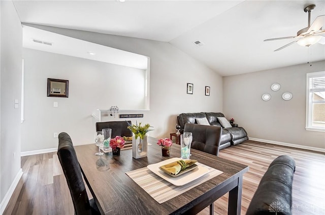 dining area with hardwood / wood-style flooring, ceiling fan, and vaulted ceiling