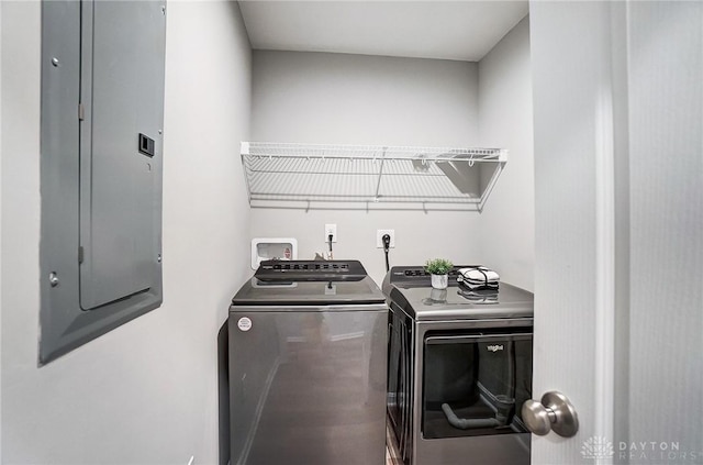 laundry area with electric panel and washing machine and clothes dryer