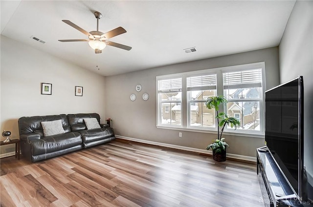 living room with ceiling fan, light hardwood / wood-style floors, lofted ceiling, and a wealth of natural light