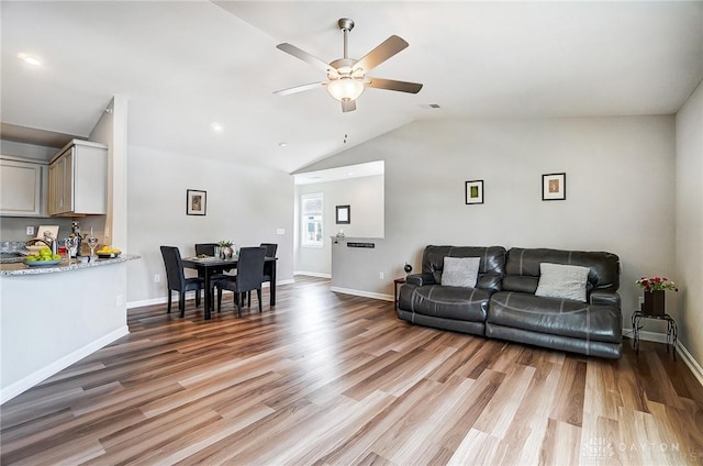 living room featuring hardwood / wood-style flooring, ceiling fan, and lofted ceiling