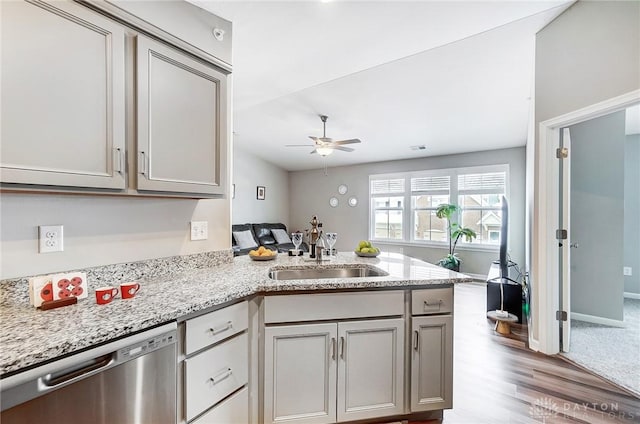 kitchen featuring ceiling fan, dishwasher, sink, kitchen peninsula, and light hardwood / wood-style floors