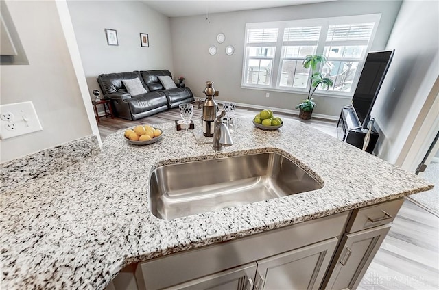 kitchen featuring light stone countertops and sink