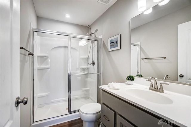 bathroom with wood-type flooring, vanity, toilet, and walk in shower