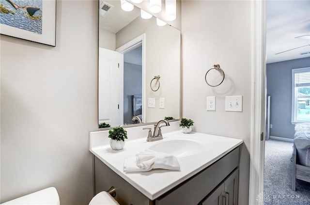 bathroom featuring ceiling fan, vanity, and toilet