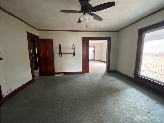 empty room featuring plenty of natural light, ceiling fan, carpet floors, and crown molding