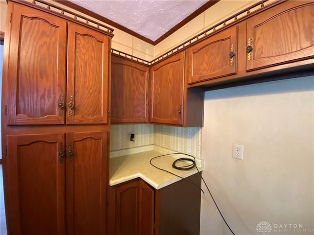 kitchen with a textured ceiling and crown molding