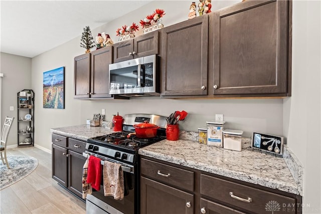 1189 Heathgate Way, Fairborn, OH 45324 - kitchen featuring light stone countertops, stainless steel appliances, baseboards, and dark brown cabinets