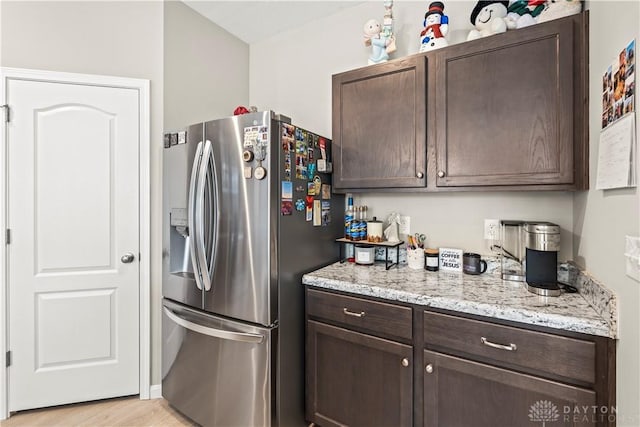 1189 Heathgate Way, Fairborn, OH 45324 - kitchen with stainless steel fridge with ice dispenser, light wood finished floors, dark brown cabinets, and light stone counters
