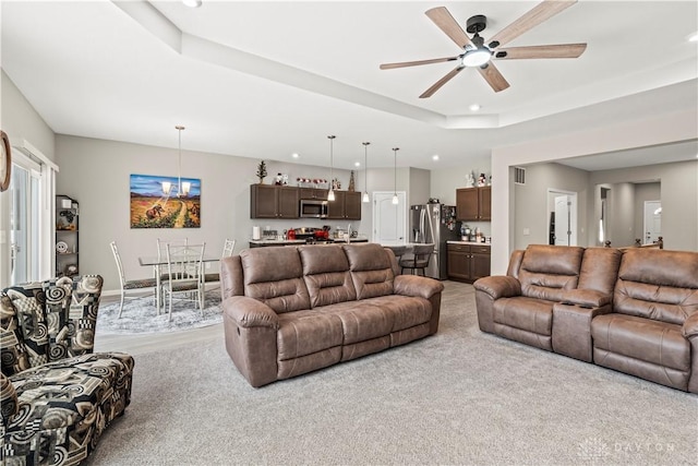 1189 Heathgate Way, Fairborn, OH 45324 - living room with ceiling fan with notable chandelier, a tray ceiling, visible vents, light colored carpet, and recessed lighting