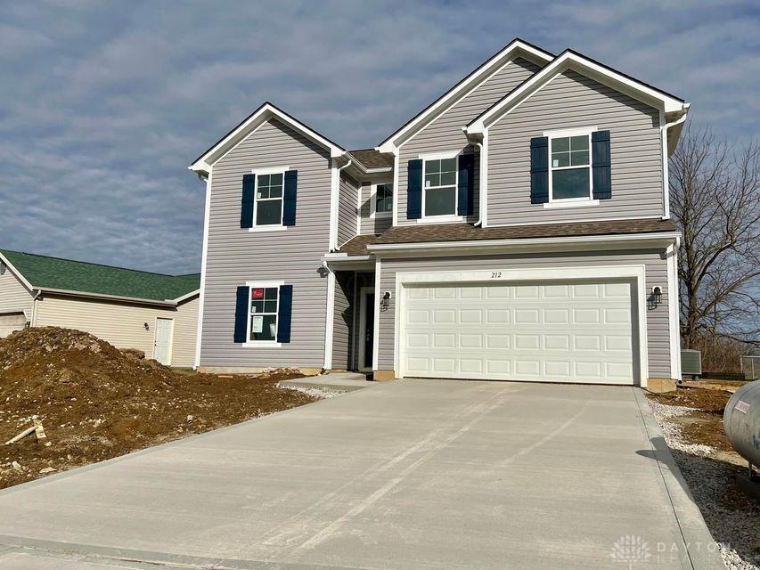 traditional home with driveway, an attached garage, and central AC unit