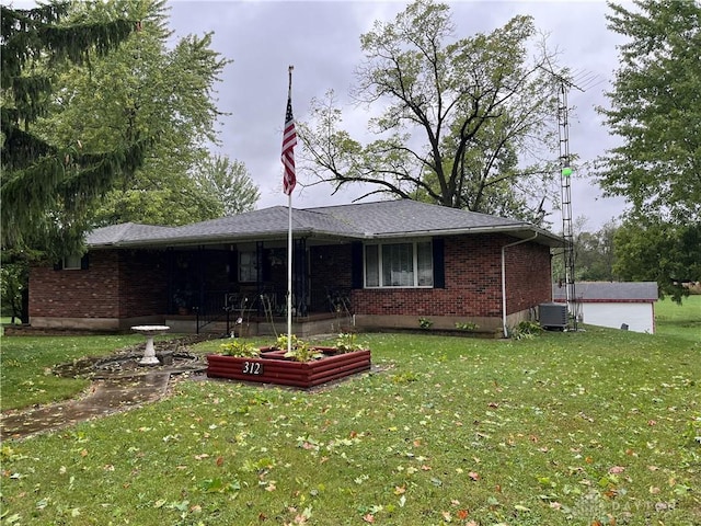 view of front of home with central AC unit and a front lawn