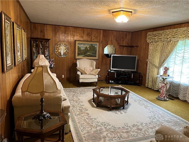 living room featuring carpet flooring, wood walls, and a textured ceiling