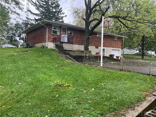 view of side of home featuring a lawn and central air condition unit