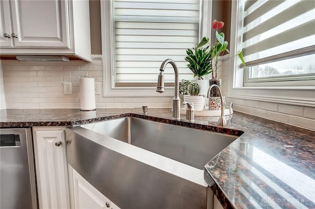 details featuring dishwasher, white cabinetry, dark stone countertops, and sink