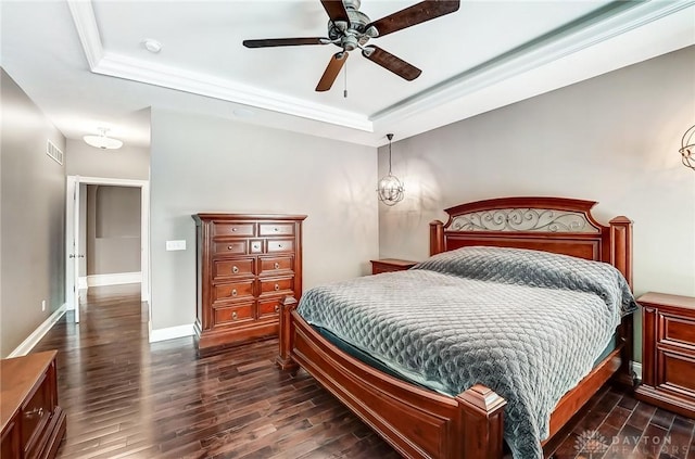 bedroom featuring ceiling fan, dark hardwood / wood-style floors, ornamental molding, and a tray ceiling