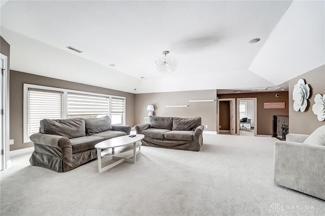 carpeted living room featuring vaulted ceiling, a raised ceiling, and a notable chandelier