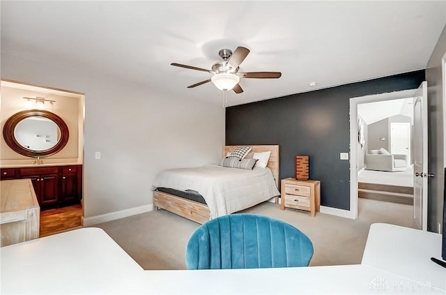 carpeted bedroom featuring connected bathroom, ceiling fan, and sink