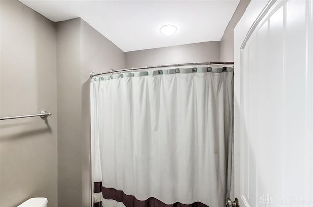 bathroom with a shower with curtain and toilet