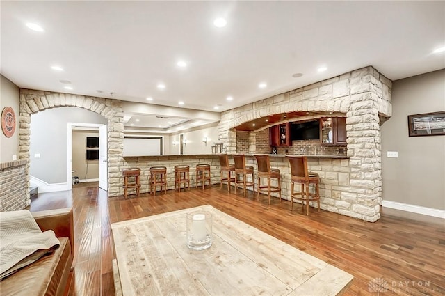 living room with hardwood / wood-style floors and indoor bar