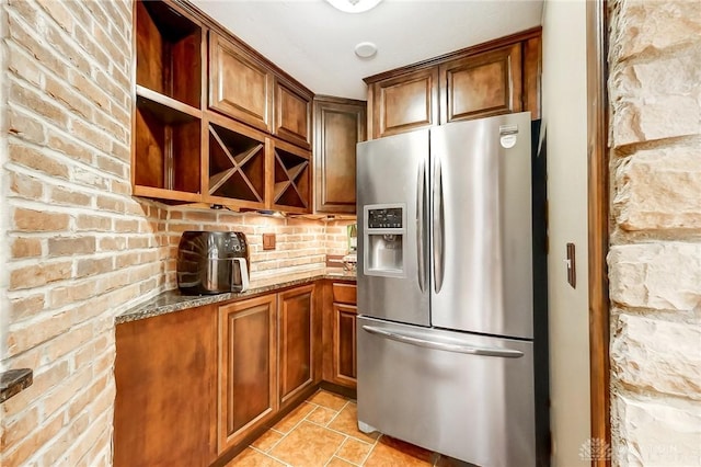 kitchen featuring stone counters and stainless steel fridge