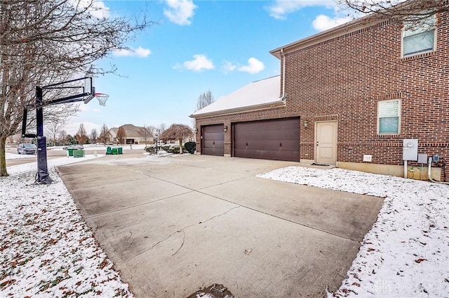 view of snow covered exterior with a garage