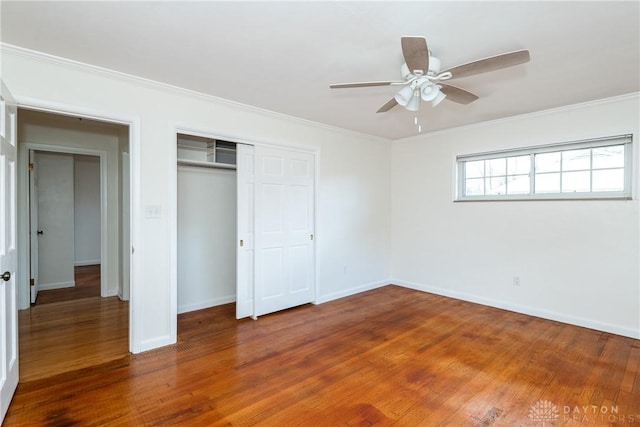 unfurnished bedroom with hardwood / wood-style floors, a closet, ceiling fan, and ornamental molding