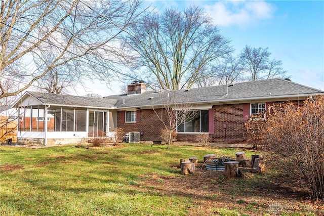 back of property featuring a lawn, a sunroom, and cooling unit