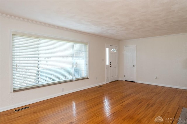 spare room featuring hardwood / wood-style flooring and crown molding