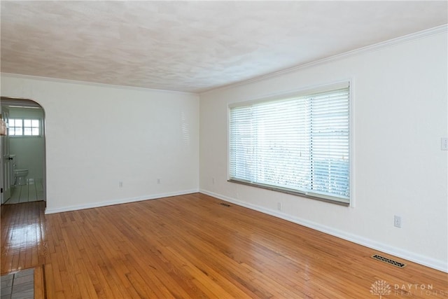 spare room with hardwood / wood-style floors and crown molding