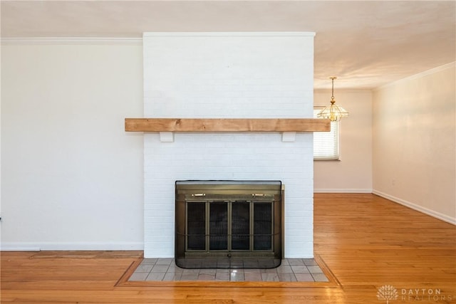 room details featuring a fireplace, wood-type flooring, a chandelier, and crown molding