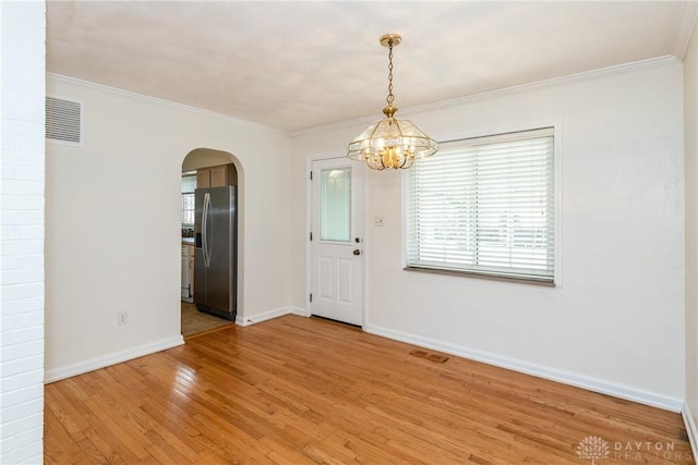 unfurnished room with crown molding, a chandelier, and wood-type flooring