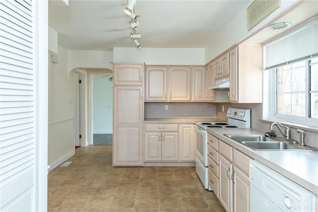 kitchen featuring sink, rail lighting, range hood, white appliances, and light brown cabinetry