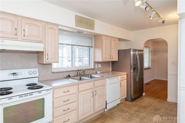 kitchen with light brown cabinetry, white appliances, tasteful backsplash, and sink