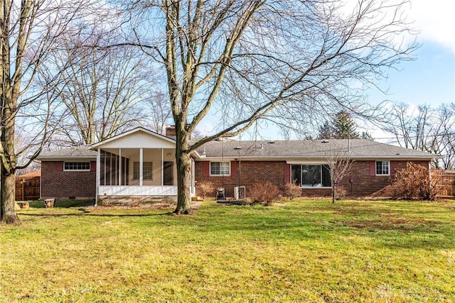 back of property featuring a lawn and a sunroom