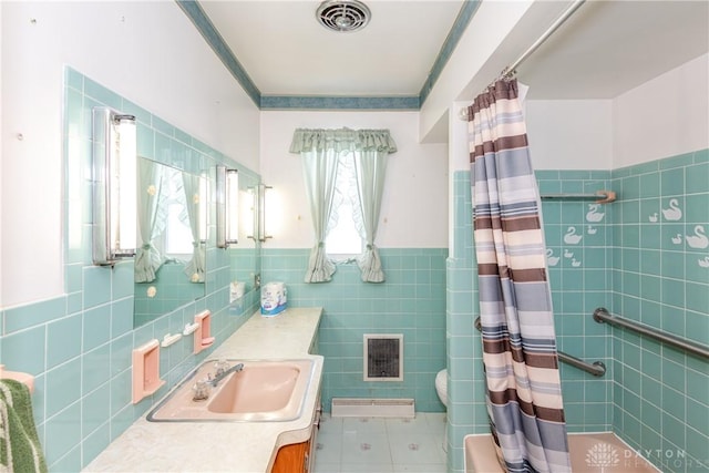 bathroom featuring vanity, tile patterned flooring, toilet, tile walls, and curtained shower