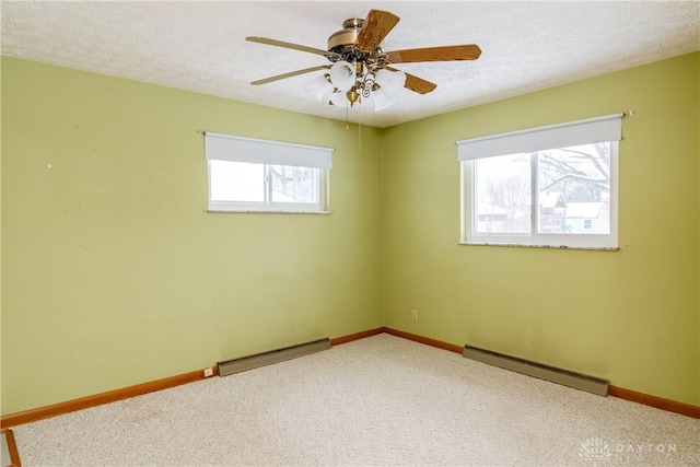 spare room featuring baseboard heating, ceiling fan, carpet floors, and a textured ceiling