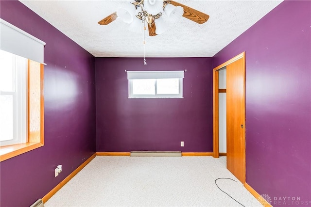 carpeted empty room featuring a textured ceiling and ceiling fan