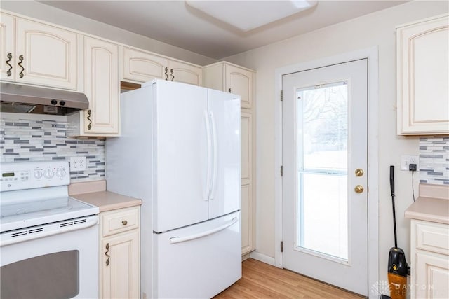 kitchen featuring light hardwood / wood-style floors, a healthy amount of sunlight, white appliances, and tasteful backsplash