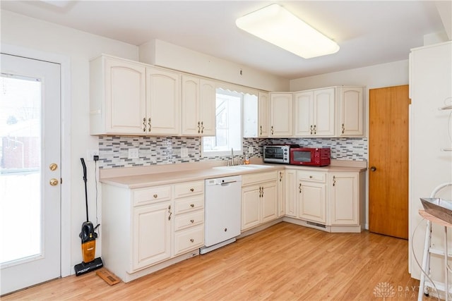 kitchen with dishwasher, light hardwood / wood-style floors, sink, and backsplash