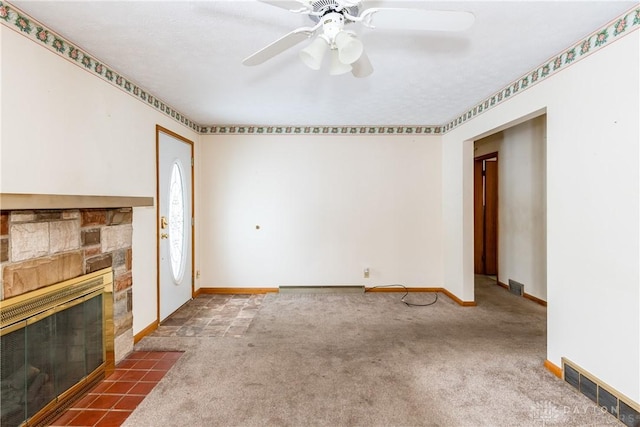 unfurnished living room with ceiling fan, a fireplace, dark carpet, and a textured ceiling