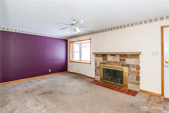 unfurnished living room with carpet flooring, ceiling fan, a stone fireplace, and a textured ceiling