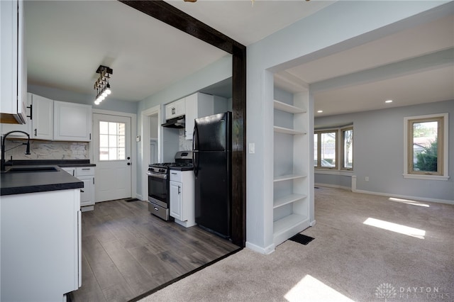 kitchen featuring white cabinets, black fridge, sink, and stainless steel range with gas stovetop