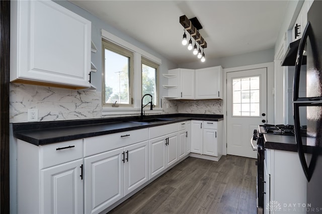 kitchen with stainless steel gas stove, tasteful backsplash, white cabinetry, and sink