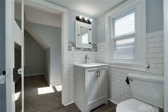 bathroom with vanity, hardwood / wood-style flooring, toilet, and tile walls