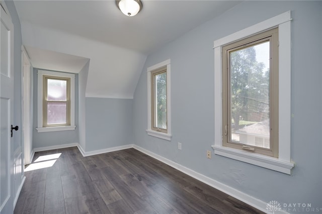 bonus room with dark wood-type flooring and lofted ceiling