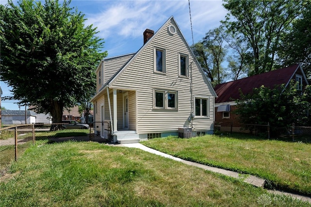 back of property with central AC and a yard