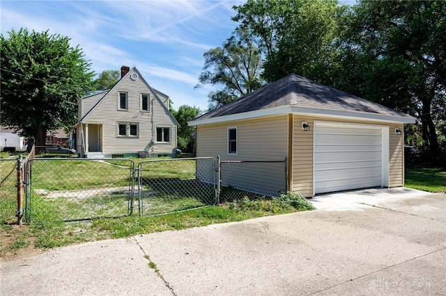 exterior space featuring an outdoor structure, a front yard, and a garage